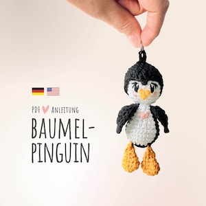 Könnte beinhalten: Häkelanleitung für einen Amigurumi-Pinguin im PDF-Format. Die Anleitung enthält Anweisungen zum Herstellen eines hängenden Pinguin-Anhängers. Die Anleitung ist sowohl in Englisch als auch in Deutsch verfügbar.