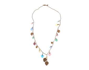 Puede incluir: Un delicado collar con un cordón marrón adornado con pequeños dijes y cuentas en forma de corazón de colores pastel. Los dijes son de varios colores pastel, incluyendo rosa, azul, verde y amarillo. El collar tiene un diseño simple y elegante.