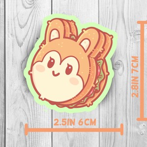 May include: A cute cartoon sandwich with a bunny face. The sandwich is made of two slices of bread with a brown crust and a filling of lettuce and tomato. The sandwich is 2.5 inches wide and 2.8 inches tall.