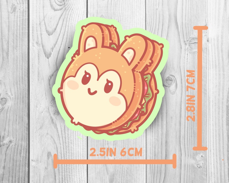 May include: A cute cartoon sandwich with a bunny face. The sandwich is made of two slices of bread with a brown crust and a filling of lettuce and tomato. The sandwich is 2.5 inches wide and 2.8 inches tall.