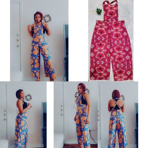 May include: A woman is wearing a blue and orange floral print jumpsuit with wide legs. The jumpsuit has a halter top with a criss-cross back strap. The woman is standing in a room with a white wall and a door in the background.