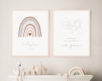 May include: Two framed prints with a minimalist design. The first print features a rainbow with a heart in the center and the text "Ayla 31 July 2020". The second print features a line drawing of a family with the text "of all the things our hands have held, the best by far is you".