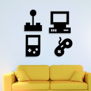 以下が含まれることがあります： 黒色の壁掛けアート。ジョイスティック、コンピューターモニター、携帯ゲーム機、ゲームコントローラーの4つのゲームをテーマにしたシルエットが特徴です。 黄色のソファの上に飾られており、モダンで遊び心のある美学を作り出しています。