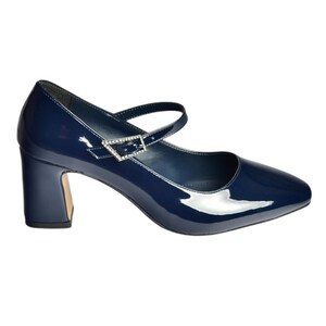 May include: Navy blue patent leather Mary Jane style shoe with a square toe and a block heel. The shoe features a strap across the top of the foot with a decorative buckle. The heel height is approximately 2.5 inches.