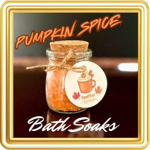 May include: A small glass jar filled with orange bath salts, tied with twine and a tag that reads "Pumpkin Spice Bath Soaks". The tag features a hand-drawn illustration of a mug of pumpkin spice latte.