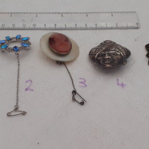 Five brooches of varying age and design.
