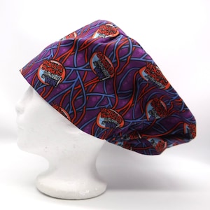 Könnte beinhalten: Lilafarbener OP-Hut mit einem sich wiederholenden Muster aus roten und blauen Adern und dem Text "Gefäßchirurgie wird nicht umsonst sein!"