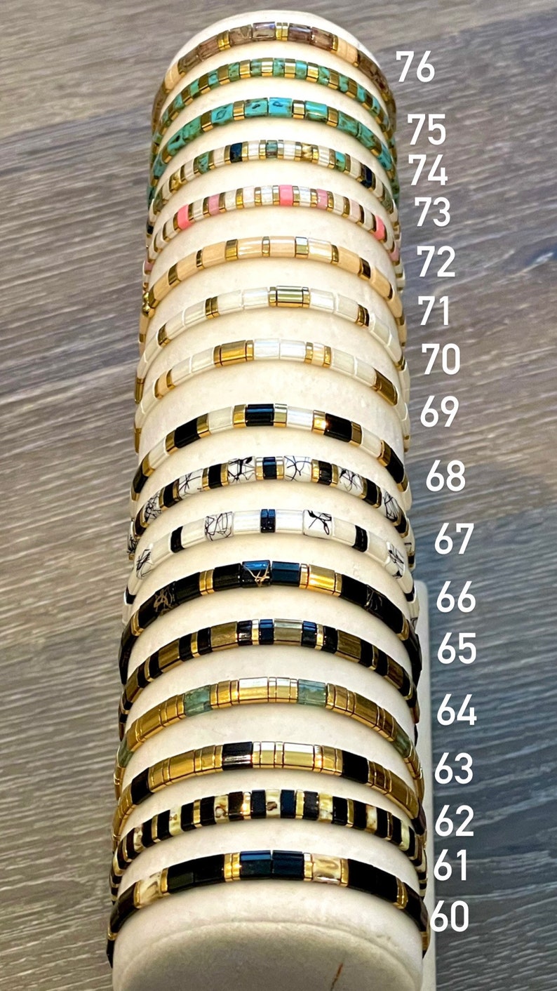 May include: A stack of 16 gold and black bracelets with different colored beads, numbered 60 to 76.
