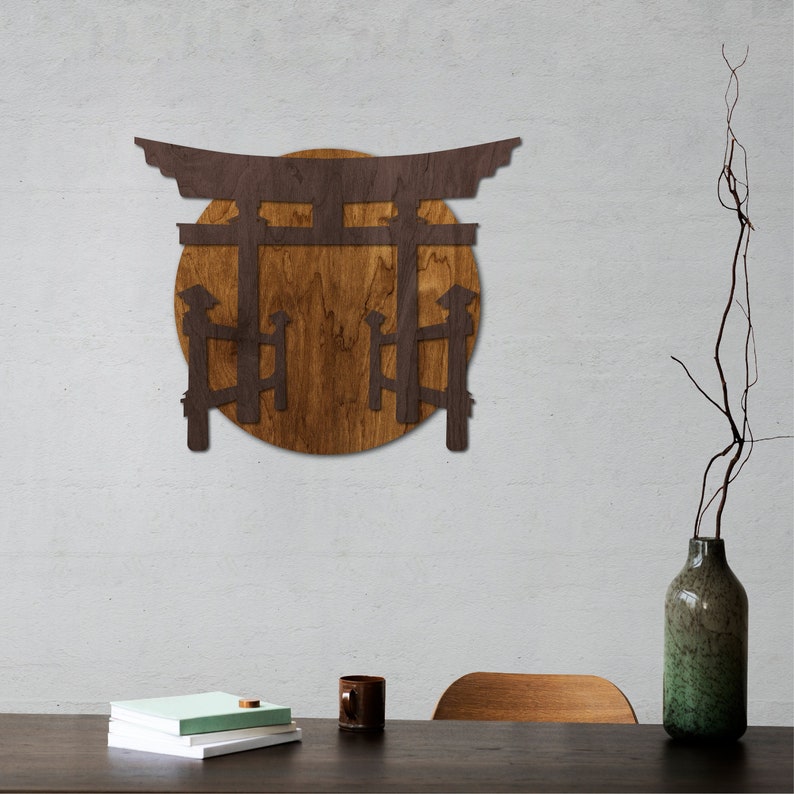 May include: A wooden wall decor featuring a Japanese torii gate with a circular wooden background. The gate is brown and the background is a light brown wood.