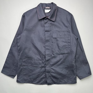 May include: A dark gray work jacket with two chest pockets and two lower pockets. The jacket has a collared neckline and long sleeves. Red stitching accents the collar and seams. The jacket is made of a durable fabric.