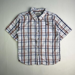 May include: White short-sleeve button-down shirt with a plaid pattern in navy blue and rust-orange. The shirt has a small pocket on the chest and a collar. The brand name is visible on the collar.