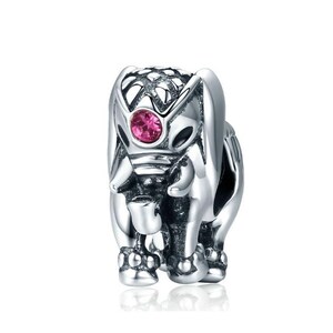 May include: Silver charm featuring a detailed elephant design with a pink gemstone eye. The elephant is standing with its trunk raised.