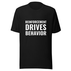 Puede incluir: Camiseta negra con texto blanco que dice "El refuerzo impulsa el comportamiento".