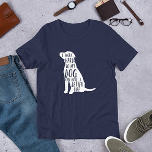 May include: Navy blue t-shirt featuring a white silhouette of a dog and the text "I work hard so my dog can have a better life".