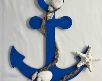 May include: A blue wooden anchor with a rope and seashells attached. The anchor is a nautical themed decoration.