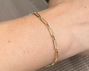 May include: A gold chain bracelet with a simple, linked design.