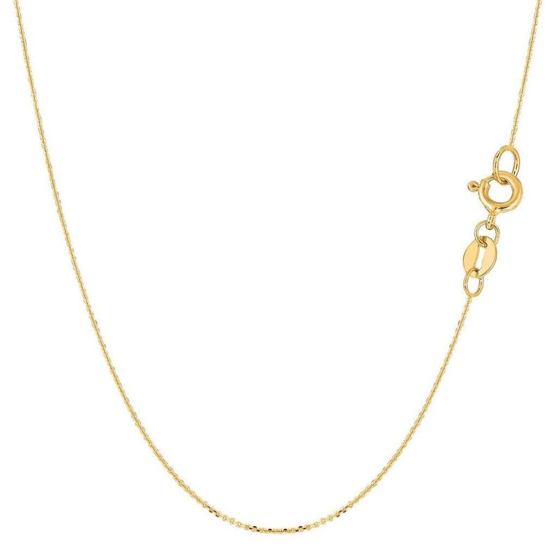 May include: A delicate gold-colored necklace with a lobster clasp. The chain has a subtle, textured pattern. The necklace is shown against a white background, highlighting its simple elegance. A classic piece of jewelry.