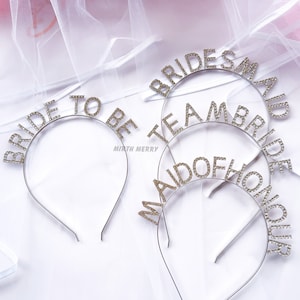 May include: Three silver headbands with rhinestones spelling out "Bride to Be", "Maid of Honour", and "Bridesmaid" on a white background.