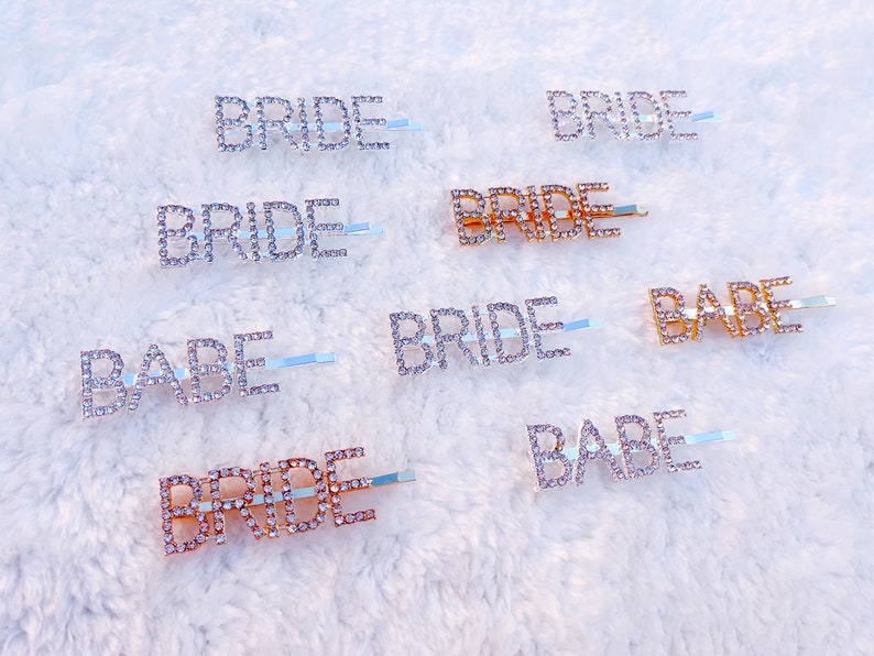 May include: A set of eight rhinestone hair clips with the words "Bride" and "Babe" in silver and gold.
