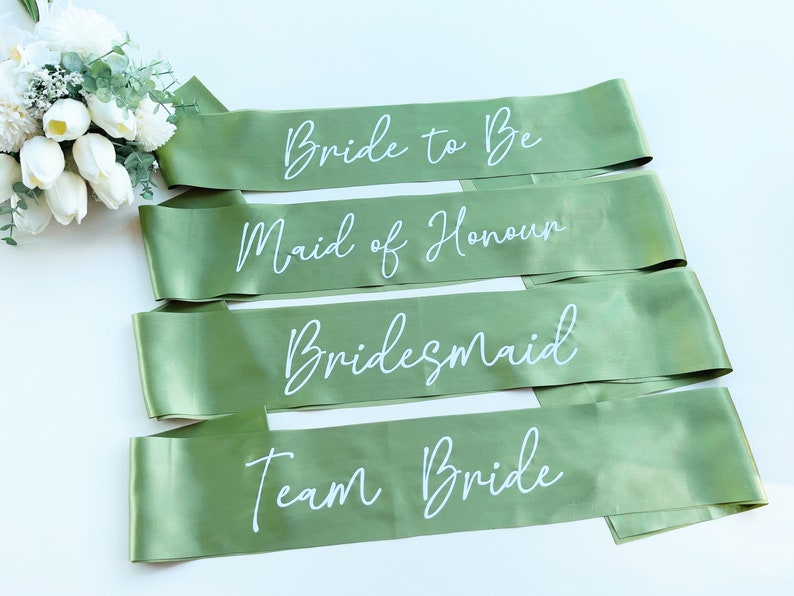 May include: Four green satin sashes with white text. The sashes read "Bride to Be", "Maid of Honour", "Bridesmaid", and "Team Bride".