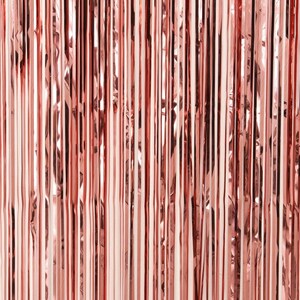 May include: A close-up of a rose gold metallic curtain made of thin strips of foil. The curtain is made of many vertical strips of foil that are overlapping.