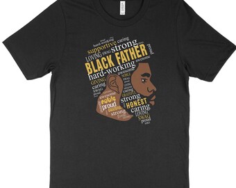 May include: Black t-shirt with a brown silhouette of a man's face. The silhouette is made up of words describing positive qualities, such as "strong", "caring", "honest", "noble", "proud", and "loving". The words are in gold and brown.