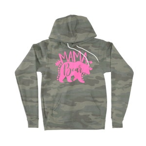May include: A camouflage green hoodie with a pink graphic that says "Mama Bear" with a pink bear silhouette and arrows.