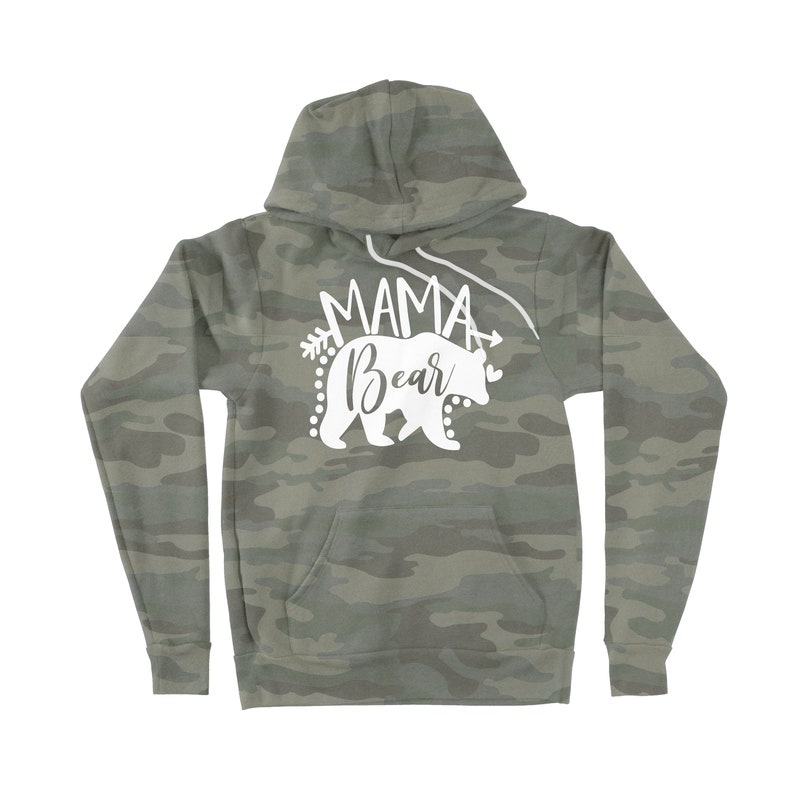 May include: A green camouflage hoodie with a white graphic of a bear and the text "Mama Bear" with an arrow on either side of the text.