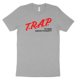 Puede incluir: Camiseta gris con texto rojo que dice "T.R.A.P. To Rise Above Poverty".