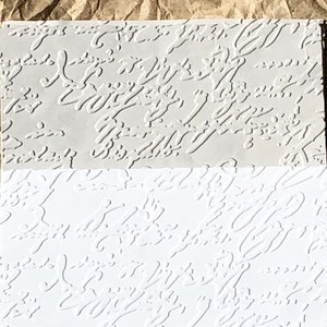 May include: Two sheets of embossed paper with a white and gray pattern. The pattern is a series of abstract swirls and lines.