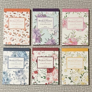 May include: Six different floral patterned notepads with the text "Broken Flower" on the front. The notepads have different colored backgrounds and floral patterns.
