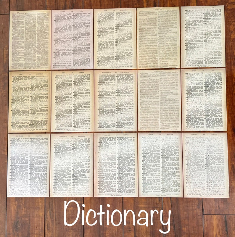 May include: A collection of 12 vintage dictionary pages, each featuring a different letter of the alphabet. The pages are printed on aged paper with a cream background and black text. The pages are arranged in a grid pattern on a wooden surface.
