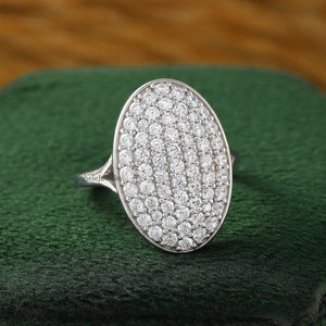 Puede incluir: Un anillo ovalado de plata con un engaste de pavé de pequeños diamantes transparentes.