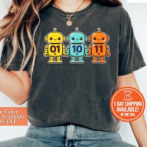 May include: A set of three ceramic mugs with a speckled, matte finish in cream, light grey, and dark grey. Each mug has a simple, minimalist design and a rounded handle.