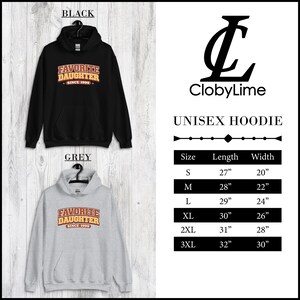 Puede incluir: Sudaderas unisex negras y grises con el texto "FAVORITE DAUGHTER SINCE 1999". Las sudaderas tienen capucha con cord&oacute;n y bolsillo delantero. La tabla de tallas muestra largos de 68.5cm a 81.3cm y anchos de 50.8cm a 76.2cm.