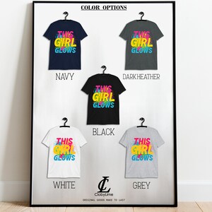 Puede incluir: Una camiseta gr&aacute;fica con el texto "This Girl Glows" en letras de colores. La camiseta est&aacute; disponible en azul marino, gris oscuro jaspeado, negro, blanco y gris.