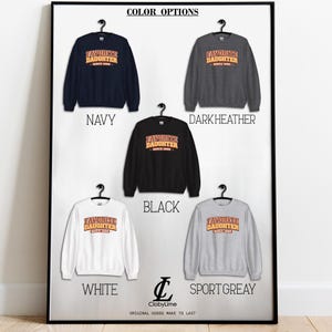 Puede incluir: Una exhibici&oacute;n enmarcada de cinco sudaderas en varios colores: azul marino, gris oscuro, negro, blanco y gris deportivo. Cada sudadera presenta el texto "FAVORITE DAUGHTER SINCE 1999" en un estilo retro. Tambi&eacute;n se ve el nombre de la marca "ClobyLime".