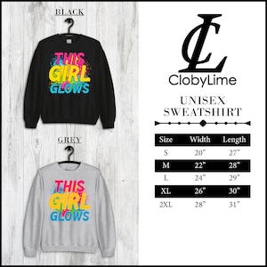 Puede incluir: Sudadera unisex con el texto "This Girl Glows" en letras de colores sobre un fondo negro y gris. La sudadera est&aacute; disponible en tallas S, M, L, XL y 2XL. La tabla de tallas muestra el ancho y la longitud de cada talla en pulgadas.