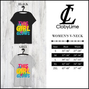 Puede incluir: Una camiseta de cuello en V negra y gris con el texto "This Girl Glows" en letras de colores. La camiseta est&aacute; disponible en tallas S, M, L, XL y 2XL. La tabla de tallas muestra las medidas de busto y cintura en pulgadas.
