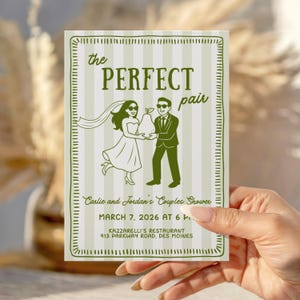 May include: A green and white invitation card with the text "the PERFECT pair" and an illustration of a bride and groom holding a pear. The card also includes event details: "Carlie and Jordan's Couples Shower, March 7, 2026 at 6 P. Kazzarelli's Restaurant, 913 Parkway Road, Des Moines."