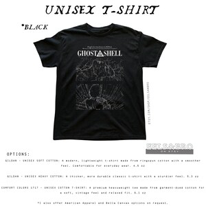 May include: A black short-sleeve t-shirt featuring a white graphic print on the chest. The design includes the text GHOST IN THE SHELL above two panels depicting stylized line art of a character and mechanical elements in a dark setting.