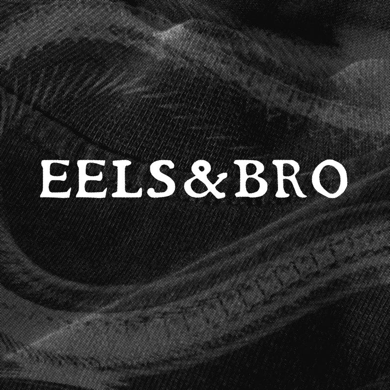 May include: A black and white graphic featuring the text EELS & BRO in a bold, serif font centered over a textured, dark fabric background with visible stitching lines and a grainy, halftone pattern throughout the entire composition.