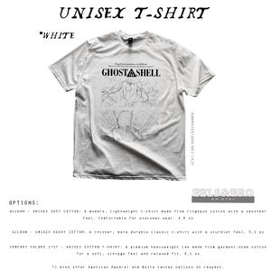 May include: A white short-sleeve t-shirt featuring a black graphic print with the text GHOST IN THE SHELL. The design includes a line art illustration of a character and intricate mechanical details. The shirt has a crew neckline and a standard fit.