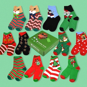 May include: A set of 12 pairs of Christmas themed socks. The socks are red, green, white, and black with various Christmas designs including reindeer, penguins, candy canes, and Christmas trees. The socks are packaged in a box with the words "Teefee Socks" and "Merry Christmas!" printed on it.