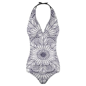 May include: White halter swimsuit with a navy blue floral mandala pattern. The one-piece swimsuit features a deep V-neck and a tie at the neck. The floral design includes leaves and swirls.