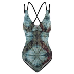 Peut inclure: Maillot de bain une pièce avec un col en V et un motif tie-dye dans les tons de bleu, marron et vert. Le maillot de bain a des bretelles noires qui se croisent dans le dos. Le tissu a un aspect texturé.