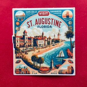 May include: A square sticker with a vibrant illustration of St. Augustine, Florida. The design depicts a coastal scene with buildings, a beach, and a sailboat. Text includes "St. Augustine Florida" and other place names.