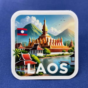 Op de afbeelding: Een vierkante sticker met een levendige illustratie van een gouden tempel, weelderige groene bergen en een rivier. De vlag van Laos is zichtbaar. Het woord "LAOS" staat in het wit afgebeeld. Een pittoreske weergave van Laos.