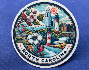 May include: A round sticker featuring a colorful illustration of North Carolina landmarks and symbols. The design includes a lighthouse, mountains, flowers, a cardinal, and the text "NORTH CAROLINA" in a circular pattern.