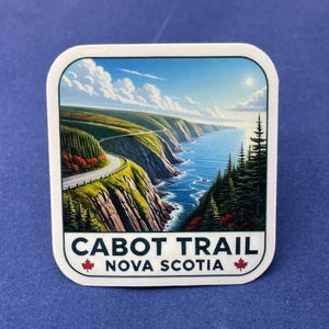 Peut inclure: Un autocollant carré représentant le Cabot Trail en Nouvelle-Écosse. L'image montre une route côtière sinueuse le long de falaises, avec des arbres et la mer sous un ciel bleu. Le texte "CABOT TRAIL NOVA SCOTIA" est affiché, avec des feuilles d'érable.